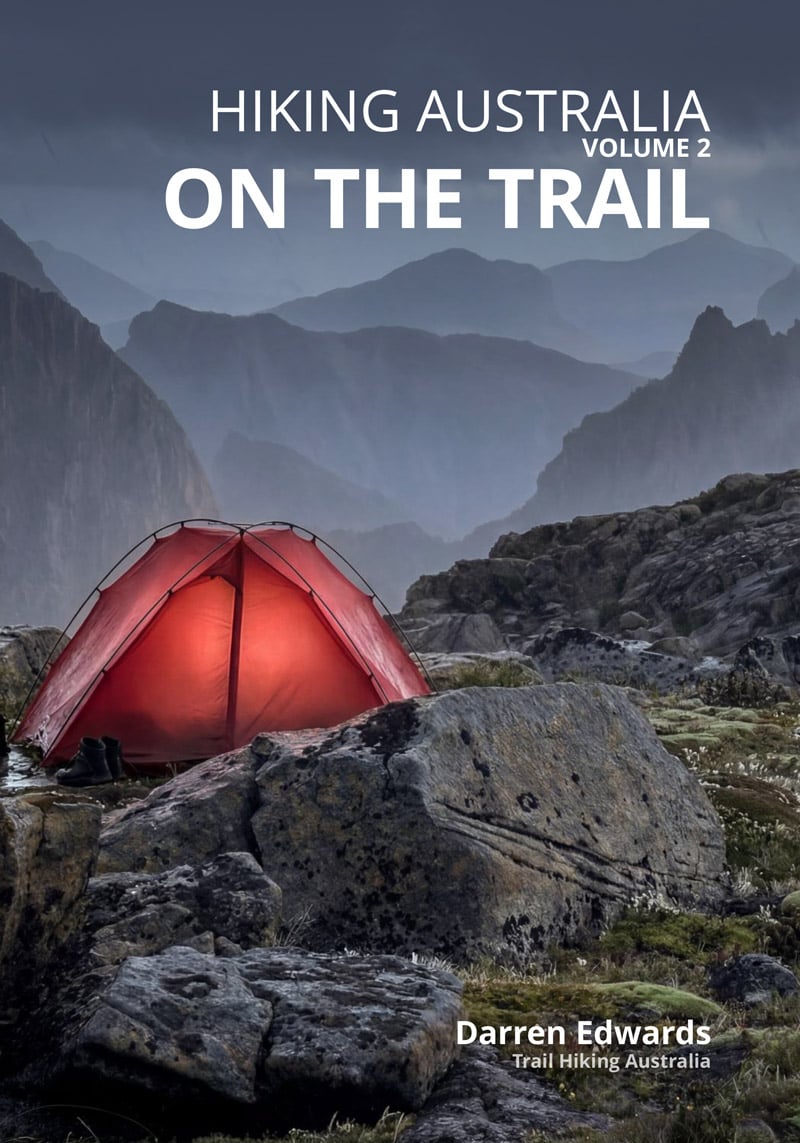 Alpine campsite with glowing red tent at dusk