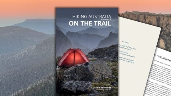 Alpine campsite with glowing red tent at dusk